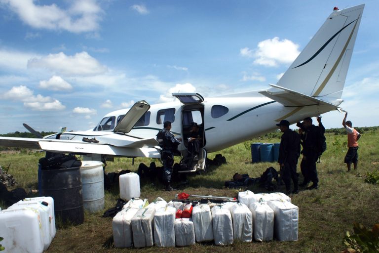 Honduran police are seen with a privately owned plane that was seized after it was found to be holding 450 Kilos of drugs in Brus Laguna