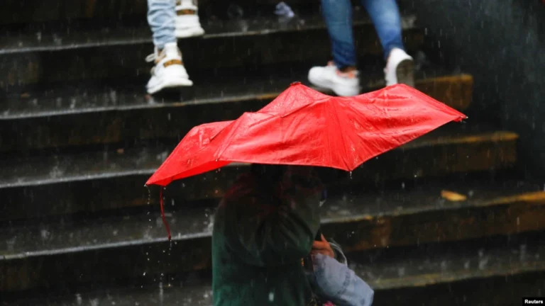 ARCHIVO - Una persona se protege de la lluvia causada por el potencial ciclón tropical dos, a su paso por el Caribe, en Caracas, Venezuela, el 29 de junio de 2022. REUTERS/Leonardo Fernández Viloria