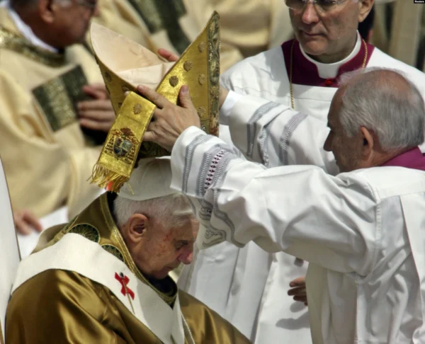 (1/7) Colocan la mitra al papa Benedicto XVI cuando se dispone a pronunciar su misa inaugural en la Plaza de San Pedro del Vaticano, el 24 de abril de 2005.