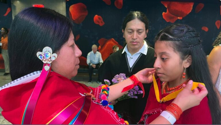 Mirian Masaquiza ayuda a su hija a vestirse mientras su esposo, Oscar, observa, mientras la pareja se unía a una boda masiva celebrada en el Lincoln Center de Nueva York, el sábado 8 de julio de 2023.