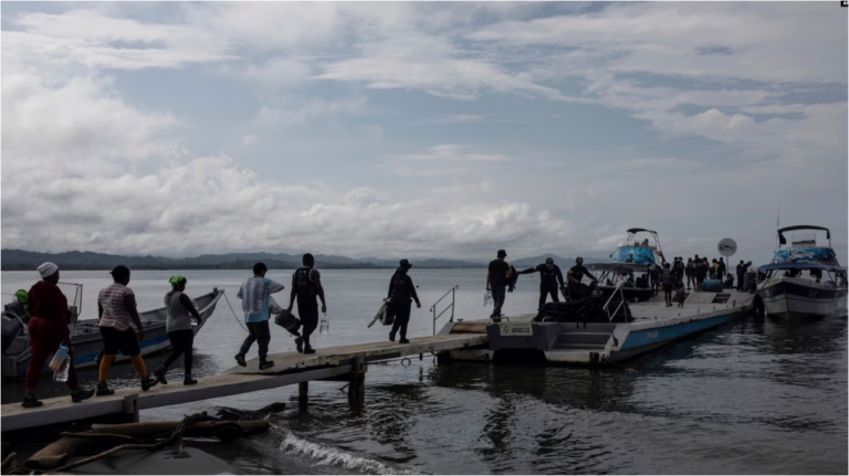 Migrantes abordan un barco hacia el Tapón del Darién, en Necoclí, Colombia, el 7 de octubre de 2023.