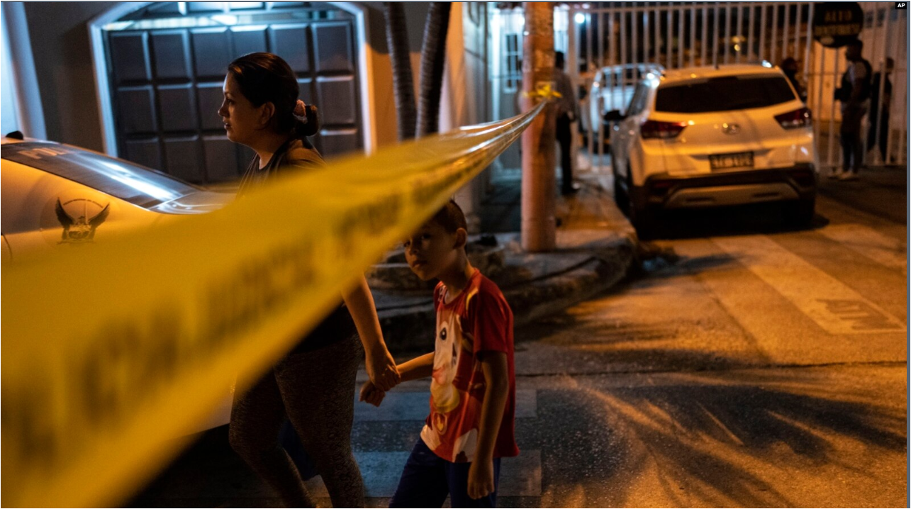 Los residentes pasan junto a la cinta policial que marca la escena del crimen para llegar a su casa en Durán, la ciudad cercana a Guayaquil, Ecuador, después de la medianoche del 28 de septiembre de 2023.