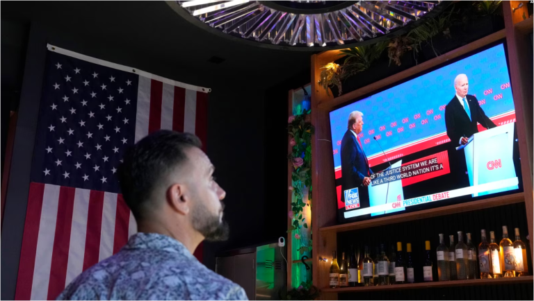 Un cliente observa al presidente Joe Biden debatir con el candidato presidencial republicano y expresidente Donald Trump durante una fiesta de observación del debate el jueves 27 de junio de 2024 en Scottsdale, Arizona.