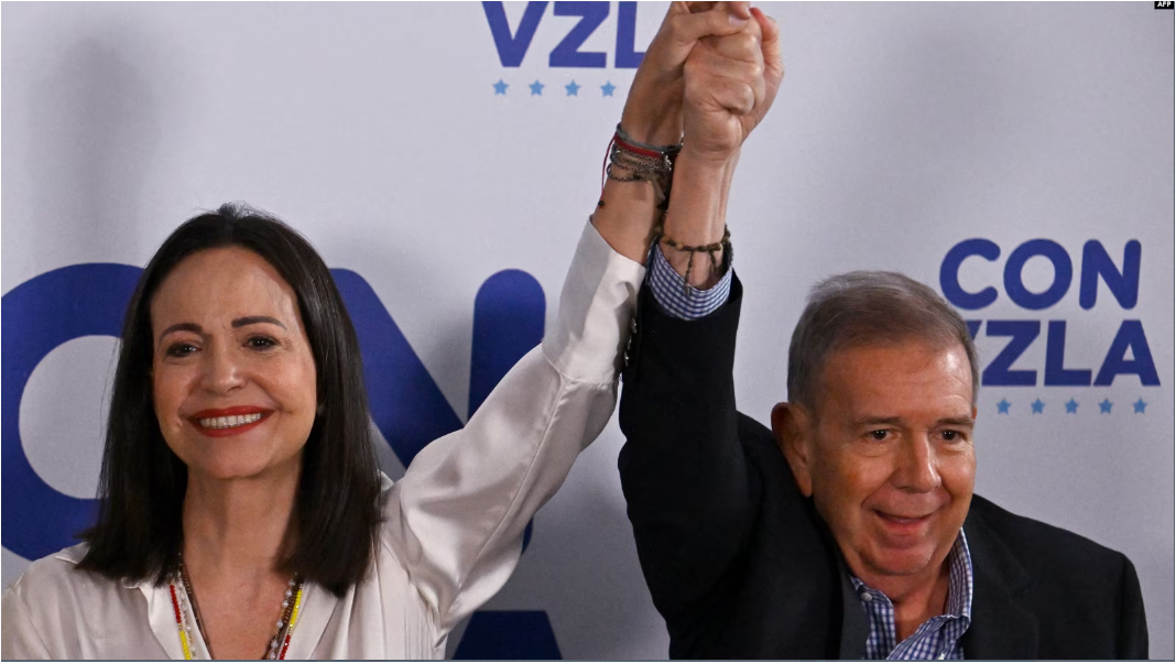 La líder de la oposición venezolana María Corina Machado levanta su mano junto a la del candidato presidencial Edmundo González Urrutia, en Caracas, el 29 de julio de 2024.