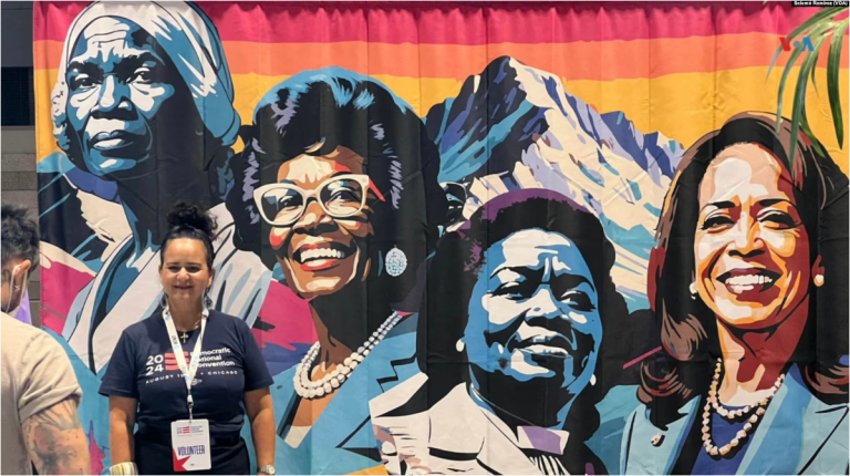 Asistentes a la Convención Nacional Demócrata en Chicago se toman fotos frente a un mural que incluye la imagen de Kamala Harris.