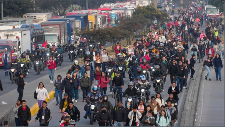 La gente camina por una calle bloqueada por camioneros que protestan por un aumento en los precios del diésel en Bogotá, Colombia, el miércoles 4 de septiembre de 2024.