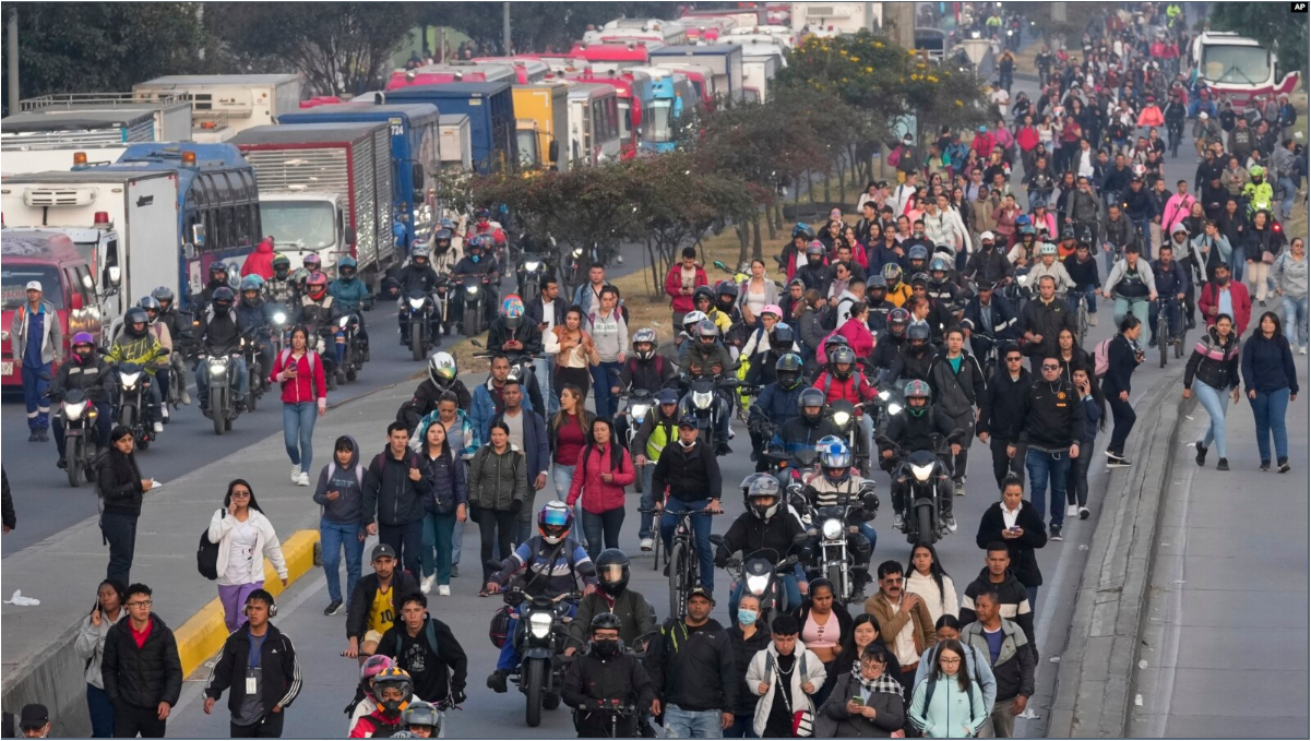 La gente camina por una calle bloqueada por camioneros que protestan por un aumento en los precios del diésel en Bogotá, Colombia, el miércoles 4 de septiembre de 2024.