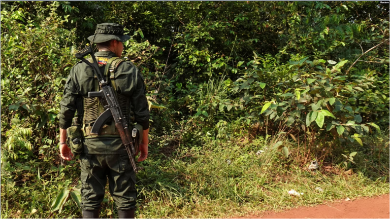 Un guerrillero del Estado Mayor Central (EMC), una facción de las FARC que rechazó el acuerdo de paz de 2016 y continuó la lucha armada, hace guardia en un puesto de control instalado en una carretera en Llanos del Yari, Colombia, el 12 de abril de 2024.